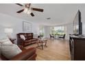 Inviting living room with wood-look flooring, comfortable leather seating, and a scenic window view at 8014 Lotus Dr, Port Richey, FL 34668