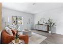 Bright living room featuring wood floors, an orange couch, a round ottoman, and modern decor at 8335 42Nd N Ave, St Petersburg, FL 33709