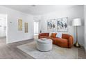 Bright living room featuring an orange couch, a round ottoman, wood floors, and modern decor at 8335 42Nd N Ave, St Petersburg, FL 33709