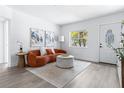 Bright living room featuring an orange couch, a round ottoman, modern decor, and a front door at 8335 42Nd N Ave, St Petersburg, FL 33709