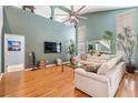 Bright living room with hardwood floors, a soaring ceiling, and a modern, oversized ceiling fan at 9806 Bennington Dr, Tampa, FL 33626