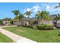 Inviting single-story home boasts a well-manicured lawn, lush landscaping, and a welcoming facade at 1 Mandarin Ter, Safety Harbor, FL 34695