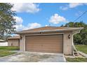 Spacious detached two-car garage with a brown door and brick siding, providing ample parking and storage at 11187 Blythville Rd, Spring Hill, FL 34608