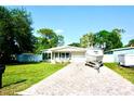 Exterior view of charming single-story home with driveway and boat at 135 Emerald Ln, Largo, FL 33771
