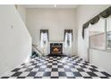Bright living area featuring a cozy fireplace, elegant window treatments and black and white checkered flooring at 15420 Aubrey Ave, Spring Hill, FL 34610