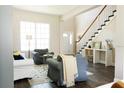 Bright living room featuring a staircase, hardwood floors, and large window for natural light at 17734 Long Ridge Rd, Tampa, FL 33647