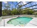Screened-in pool with a lovely waterfall feature, tile surround, and meticulously maintained space at 18914 Geraci Rd, Lutz, FL 33548