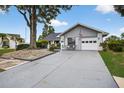 Inviting single-story home with well-maintained landscaping, a cozy bench, and an attached garage for convenience at 205 Wimbly Pl, Sun City Center, FL 33573