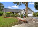 Charming single-story home showcasing lush landscaping, mature trees, and a classic residential appeal at 205 Wimbly Pl, Sun City Center, FL 33573
