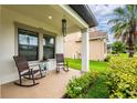 Inviting covered front porch featuring seating for relaxing and enjoying the outdoors at 21395 Southern Charm Dr, Land O Lakes, FL 34637
