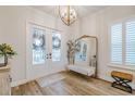 Bright entryway with a glass double door, chandelier, large mirror, bench, and hardwood floors at 2388 Oakwood Preserve Dr, Wesley Chapel, FL 33543