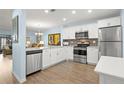 Bright kitchen with stainless steel appliances, white cabinets, and open layout at 2400 Winding Creek Blvd # 4-101, Clearwater, FL 33761