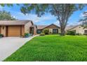 Charming single-story home boasting a lush front lawn, complemented by mature trees and colorful flowerbeds for enhanced curb appeal at 2475 Bay Berry Dr, Clearwater, FL 33763