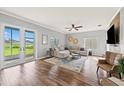 Spacious living room with wood floors, comfortable seating, and backyard access at 25521 Bruford Blvd, Land O Lakes, FL 34639
