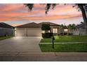Charming single-story home featuring a three-car garage and a well-manicured lawn at 2814 Duncan Tree Cir, Valrico, FL 33594