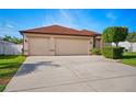 Exterior view of a three-car garage with a concrete driveway and manicured landscaping at 2814 Duncan Tree Cir, Valrico, FL 33594