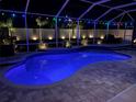 Inviting screened-in pool featuring colorful string lights, exterior illumination, and hardscape at 2814 Duncan Tree Cir, Valrico, FL 33594
