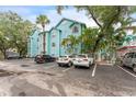 Low angle view of a light blue three-story building with a lush tropical landscaped parking lot at 3002 W Cleveland St # D4, Tampa, FL 33609