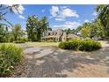 Spacious property showcasing a charming two-story home with a long driveway and lush landscaping, offering serene privacy at 3018 Pemberton Trace Ct, Plant City, FL 33565