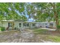 Charming single-story home with a covered parking area, well-maintained landscaping, and mature trees at 3203 21St Se Ave, Ruskin, FL 33570
