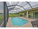 Relaxing screened-in pool area with an outdoor kitchen and bar overlooking the lush backyard at 3212 E Merrin Rd, Plant City, FL 33567