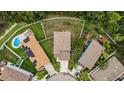 An aerial view of homes with fenced yards, some featuring pools and solar panels, set in a lush neighborhood at 3305 Hoylake Ct, Land O Lakes, FL 34638