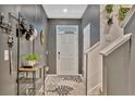 Stylish entryway featuring a gray accent wall, decorative rug, and practical storage solutions at 3320 Pleasant Willow Ct, Brandon, FL 33511