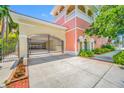 Exterior view of a gated entrance leading to the garage, with tropical landscaping and a peach and yellow color scheme at 340 1St N St # I, St Petersburg, FL 33701