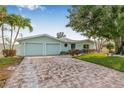Charming home with a brick driveway, beautiful landscaping and a spacious two-car garage at 352 La Hacienda Dr, Indian Rocks Beach, FL 33785