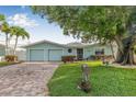 Charming home with a brick driveway, beautiful landscaping and a spacious two-car garage at 352 La Hacienda Dr, Indian Rocks Beach, FL 33785
