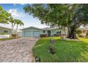 Charming home with a brick driveway, beautiful landscaping and a spacious two-car garage at 352 La Hacienda Dr, Indian Rocks Beach, FL 33785