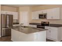 Bright kitchen with stainless steel appliances, center island and white cabinetry at 37147 Sagemoor Dr, Zephyrhills, FL 33541