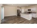 Open-concept living room and kitchen with stainless appliances and sliding doors at 37147 Sagemoor Dr, Zephyrhills, FL 33541