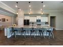 Spacious kitchen features white cabinets, a large island with seating, and modern appliances at 3895 Tate Ct, North Port, FL 34288