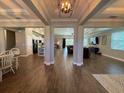 Open-concept living space with elegant wood-look tile flooring and high ceilings, great for entertaining at 3895 Tate Ct, North Port, FL 34288