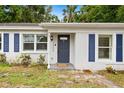Close-up of front door with blue shutters, clean stucco, and an inviting entrance at 3906 W Rogers Ave, Tampa, FL 33611