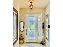 Elegant entryway with stylish decor, including a decorative glass door and sophisticated light fixture at 5103 98Th E Ave, Parrish, FL 34219