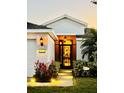 Inviting home exterior featuring a well-lit entryway, manicured lawn and landscape, and a welcoming ambiance at 5103 98Th E Ave, Parrish, FL 34219