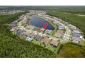 An aerial view showcases the neighborhood around a lake with mature trees surrounding the area at 6109 Marsh Trail Dr, Odessa, FL 33556