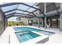 A large enclosed pool with a spa and lounge chairs on the surrounding deck at 6109 Marsh Trail Dr, Odessa, FL 33556
