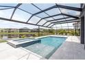 Stunning screened-in pool area with hot tub, overlooking a serene lake at 6109 Marsh Trail Dr, Odessa, FL 33556