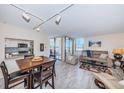 A sunlit living room featuring modern furniture, light floors, and sliding glass doors to a balcony at 6145 Sun Blvd # 404, St Petersburg, FL 33715