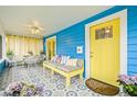 Inviting front porch with bright yellow door and comfortable seating with stylish tile flooring at 661 14Th S Ave, St Petersburg, FL 33701