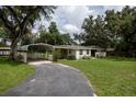 This property showcases a covered carport and well-maintained front yard at 7240 Ottley St, Zephyrhills, FL 33541