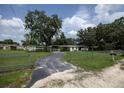 Charming property with a circular driveway, lush green lawn, and mature trees at 7240 Ottley St, Zephyrhills, FL 33541