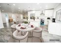 Bright, open kitchen with white cabinets, stainless appliances, and an island with breakfast bar seating at 913 Spindle Palm Way, Apollo Beach, FL 33572