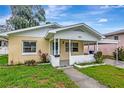 Inviting single-story home with a covered porch, landscaped yard, and freshly painted exterior at 963 27Th S Ave, St Petersburg, FL 33705