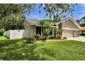 Landscaped front yard with lush green grass and mature trees on a sunny day at 12219 Steppingstone Blvd, Tampa, FL 33635