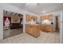 Open kitchen with wood cabinets and tile flooring flowing into the spacious living room at 1235 Bass Blvd, Dunedin, FL 34698