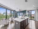 Modern kitchen with island and stainless steel appliances, seamlessly connected to the open-concept living area with cityscape views at 132 Mirror Lake N Dr # 501, St Petersburg, FL 33701